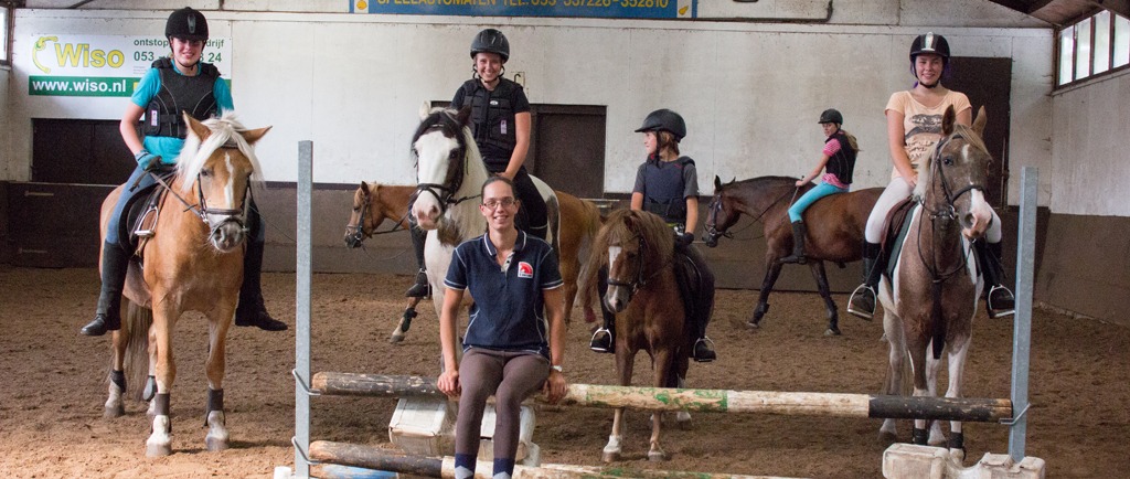 Een instructrice geeft les in de binnenbak.